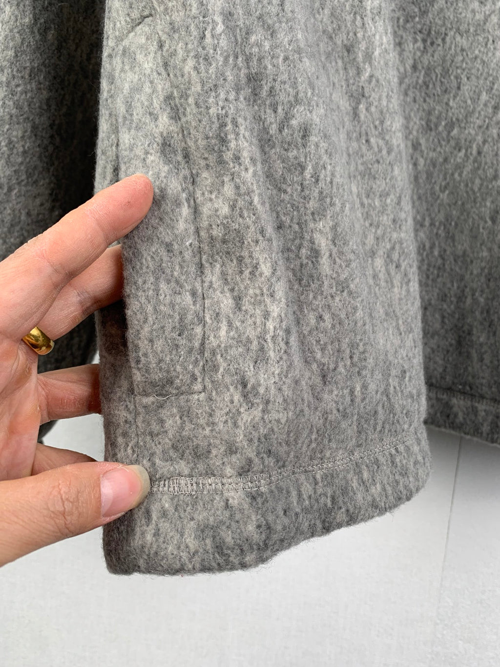 Gray jacket hem with stitched cuff edge and textured fabric