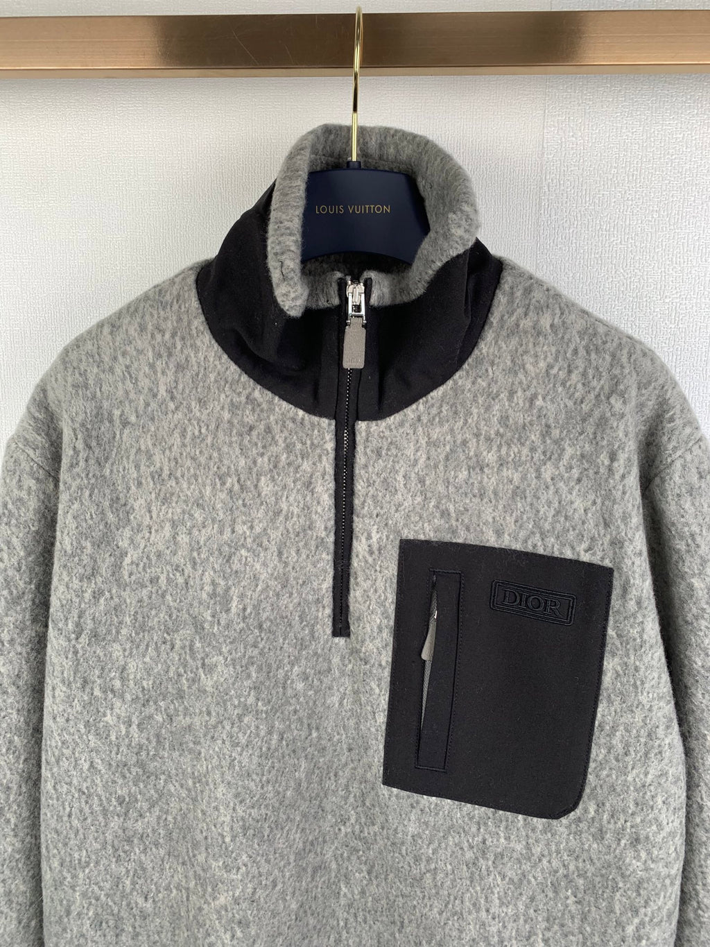 Gray zip jacket with black stand collar, zipper pull, and square chest pocket
