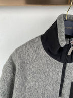 Gray zip jacket with black stand collar, front zipper, and metal pull tab