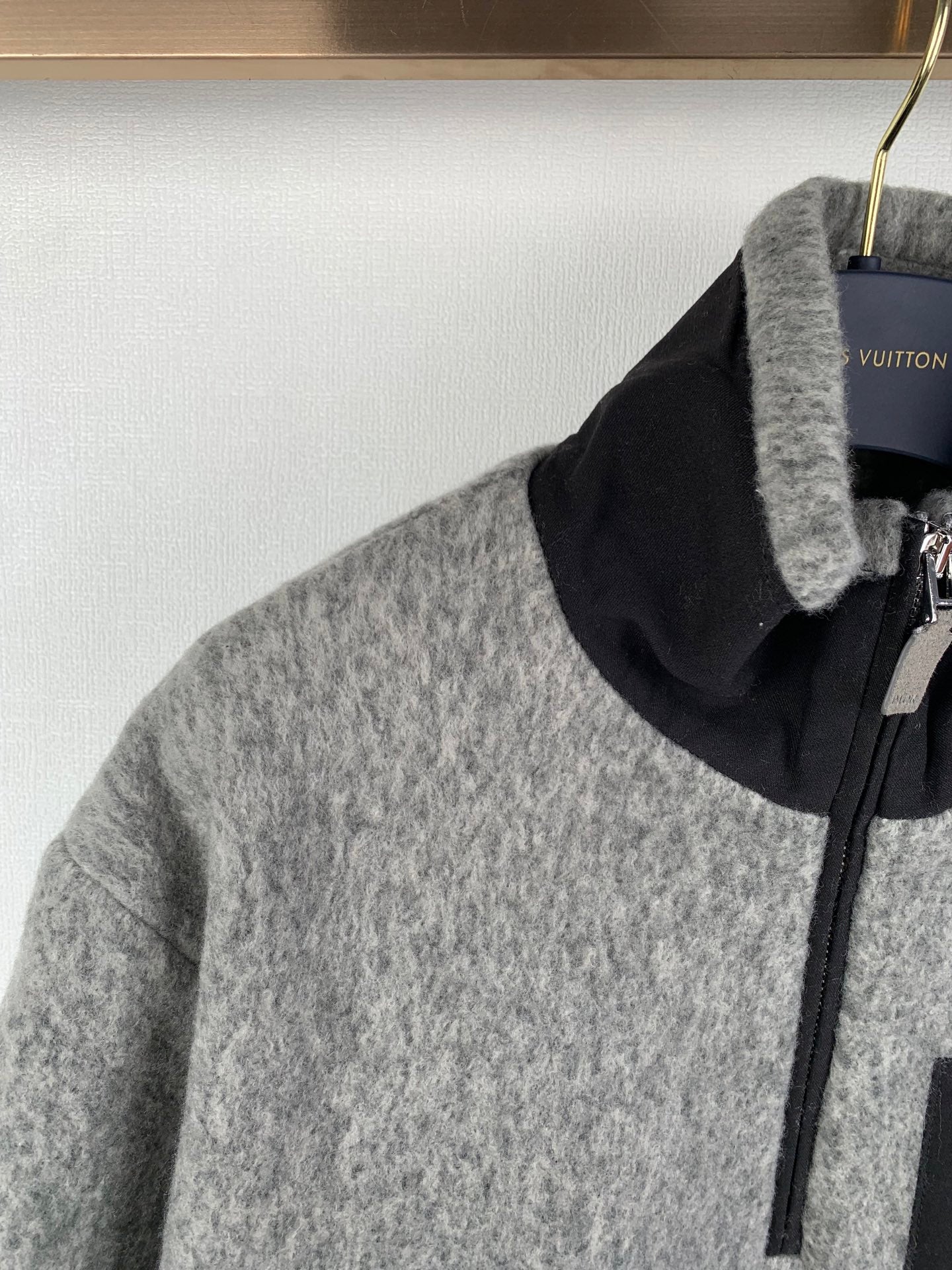 Gray zip jacket with black stand collar, front zipper, and metal pull tab