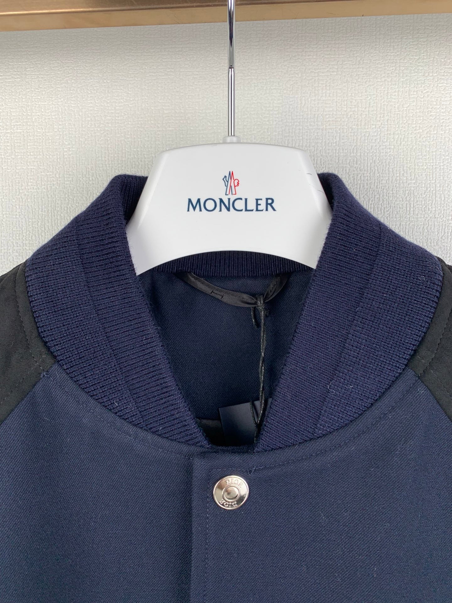Navy long-sleeve jacket with gray sleeves, ribbed stand collar, Moncler logo on inner label