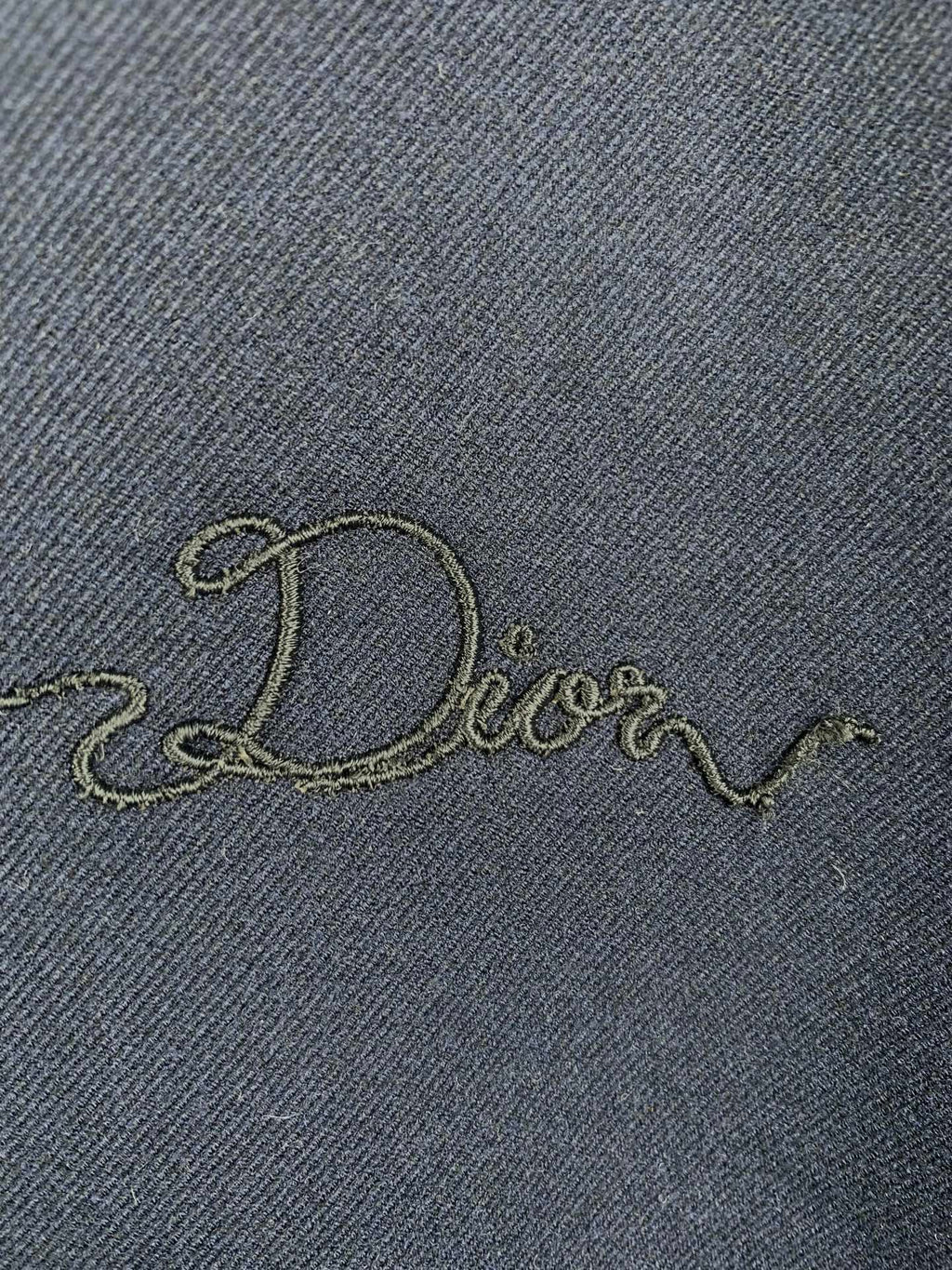 Embroidered Dior script on dark navy jacket fabric