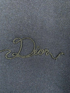Embroidered Dior script on dark navy jacket fabric