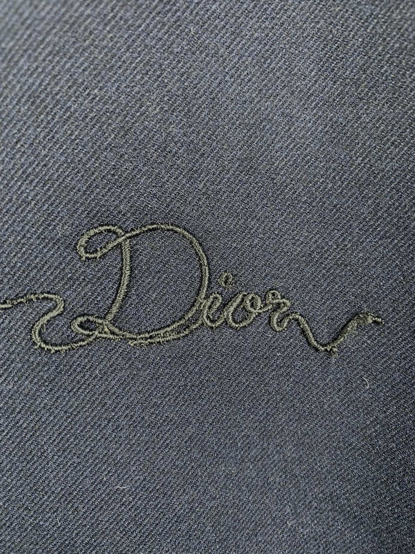 Embroidered Dior script on dark navy jacket fabric