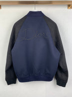 Back view of long-sleeve jacket in dark navy with gray sleeves, Dior script embroidery