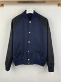 Long-sleeve jacket in dark navy with gray sleeves, snap buttons, stand collar, ribbed hem
