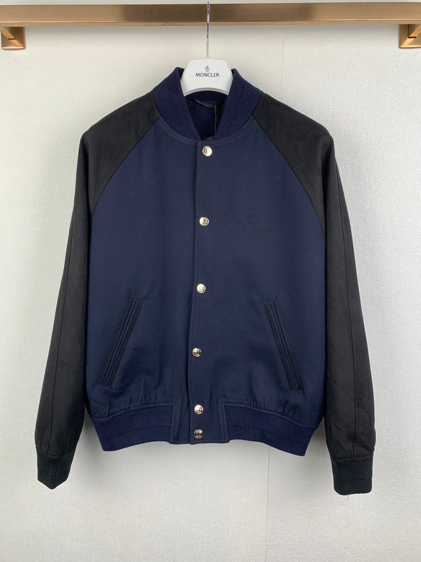 Long-sleeve jacket in dark navy with gray sleeves, snap buttons, stand collar, ribbed hem