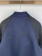 Back collar area of dark navy jacket with gray sleeves, Dior script embroidery on yoke