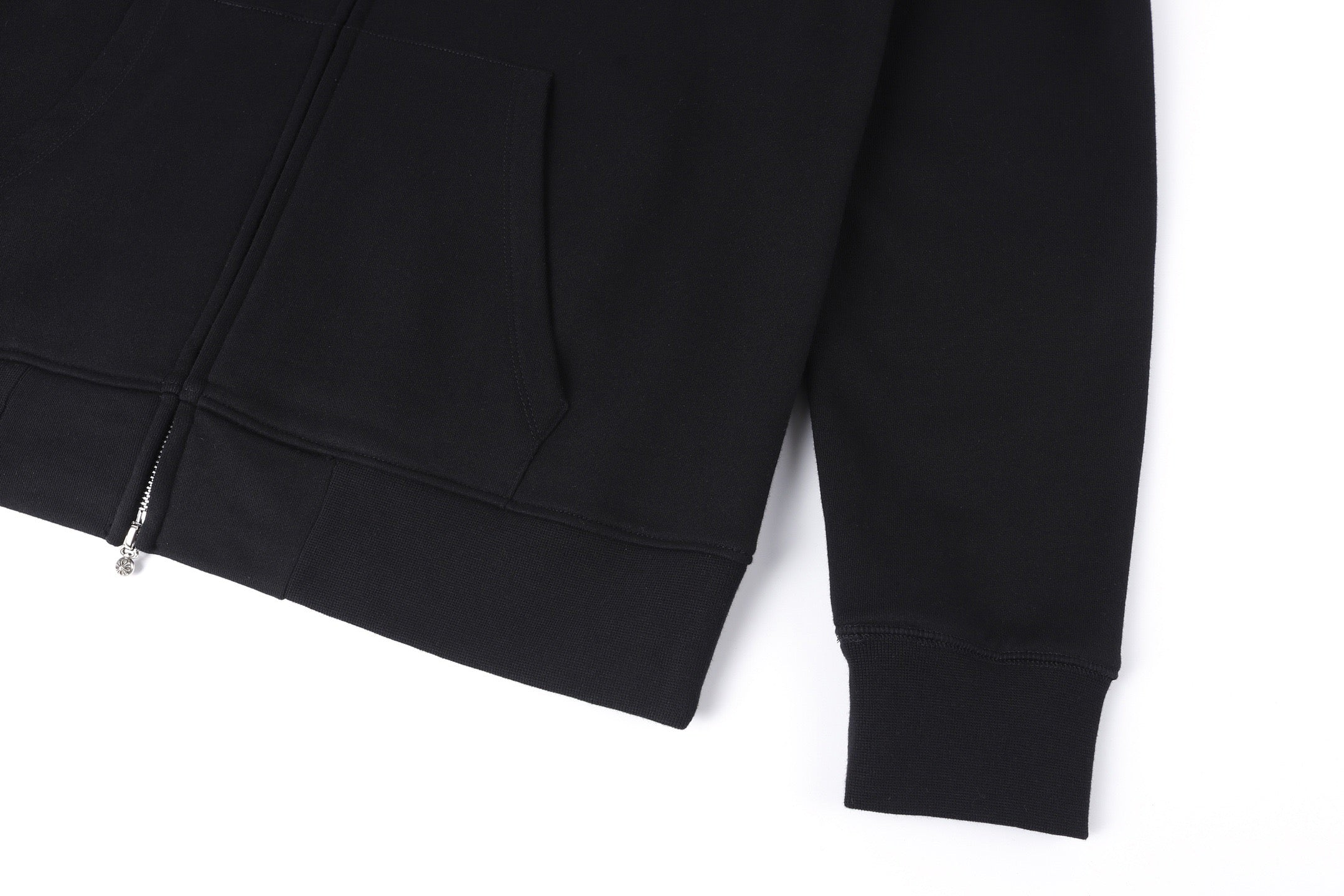 Dark hoodie with long sleeves, cuffs, and hem near the front zipper placket