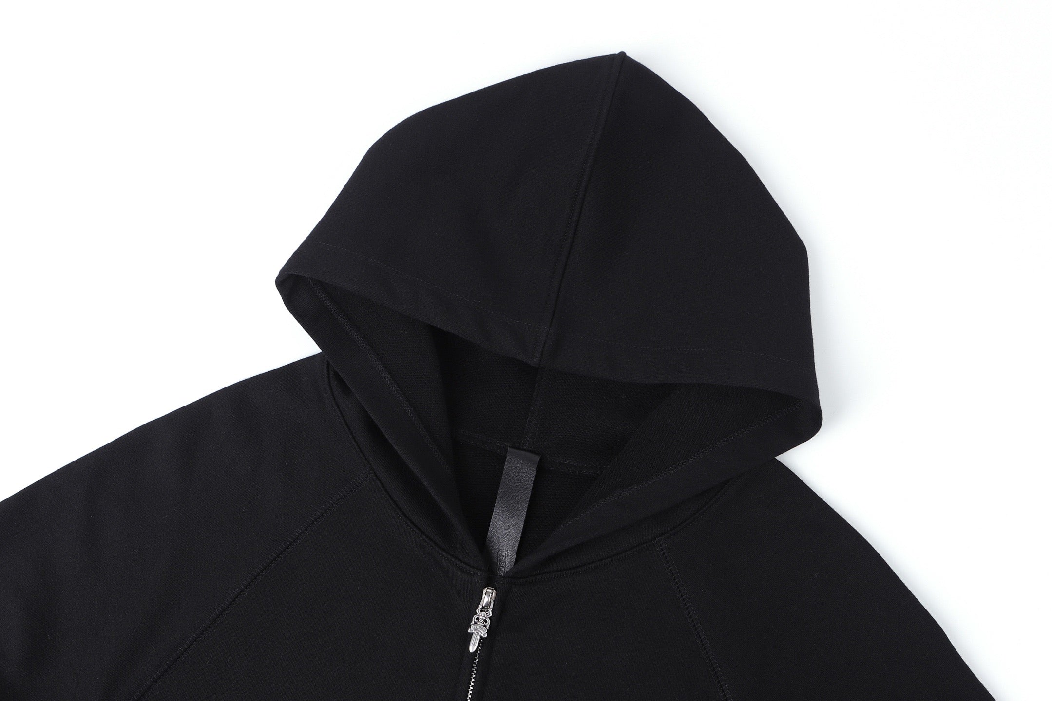 Dark zip-up hoodie with hood and metal zipper, close-up view