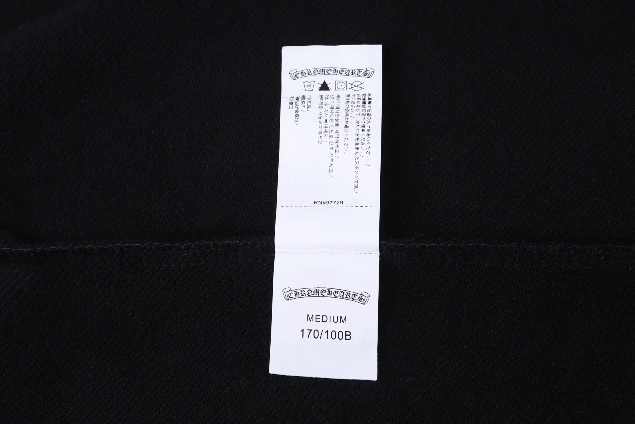 Dark hoodie with white size and care label on inner back neck