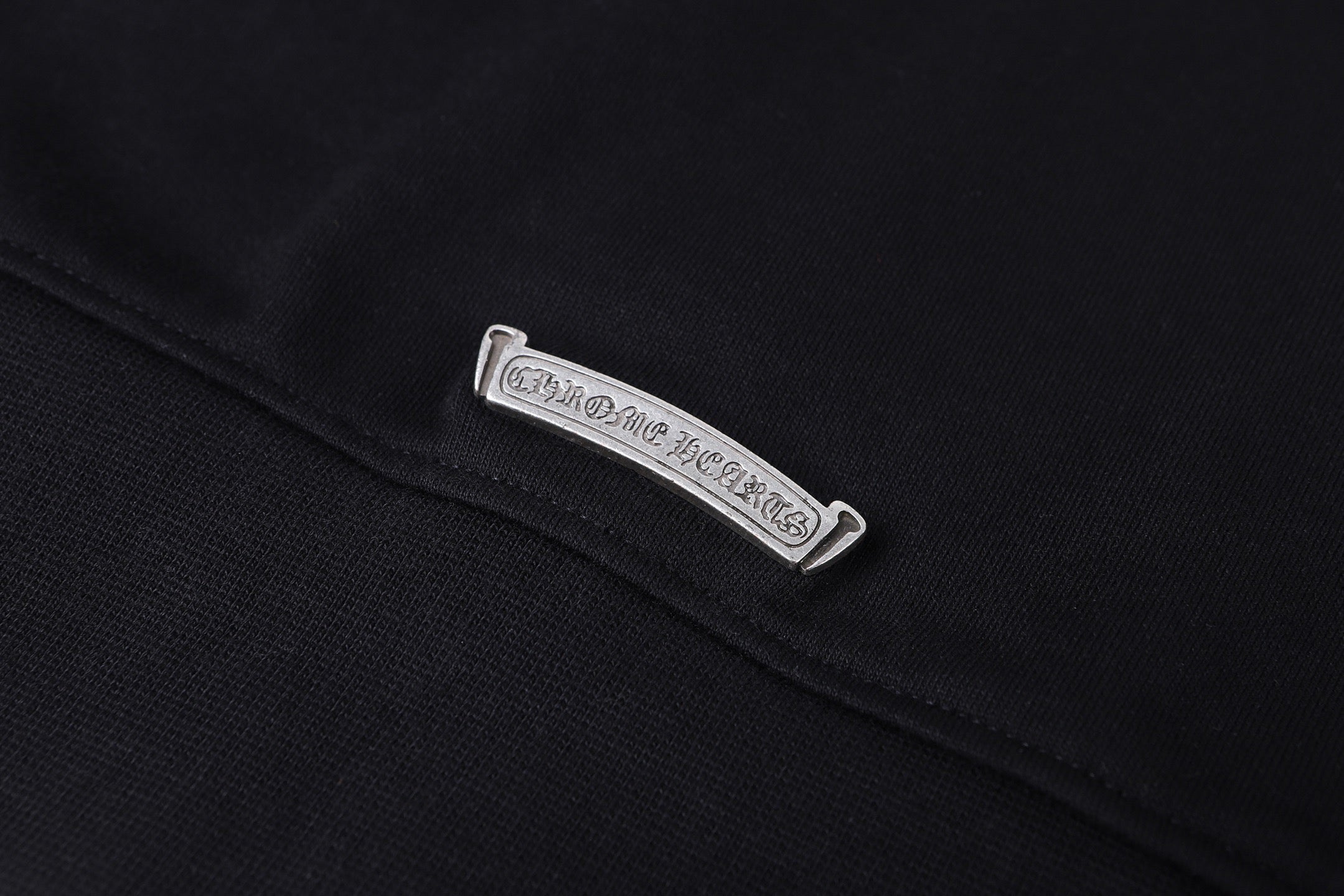 Dark hoodie with rectangular care label on the collar seam