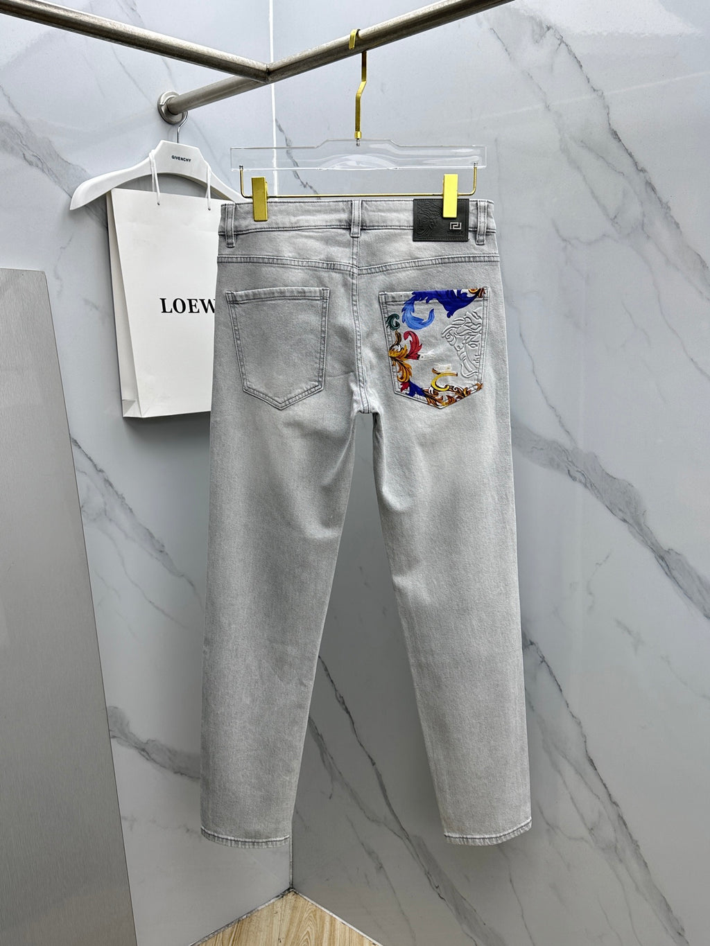 Versace light-gray denim jeans with front pocket panel featuring colorful baroque print