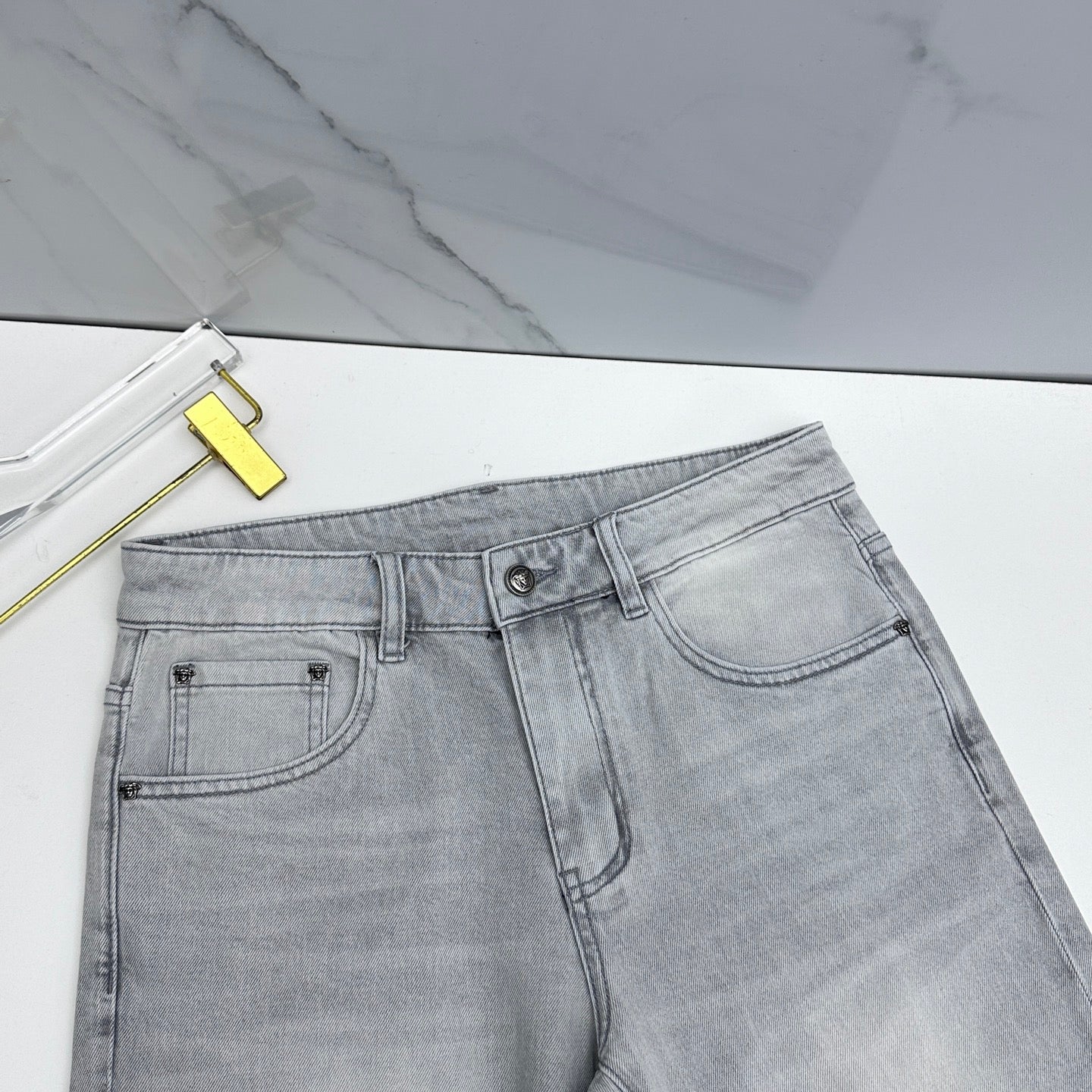 Light-wash jeans front with belt loops, button closure, and curved pocket