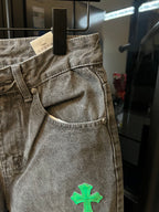 Light gray denim pants with front fly and green cross patch on the leg