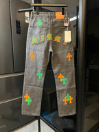 Light gray denim pants with neon cross and letter-style patches on the front