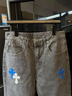 Light gray denim pants with blue cross embroidery, front pockets and waistband