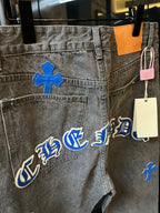 Light gray denim pants with blue gothic-style lettering and cross patches