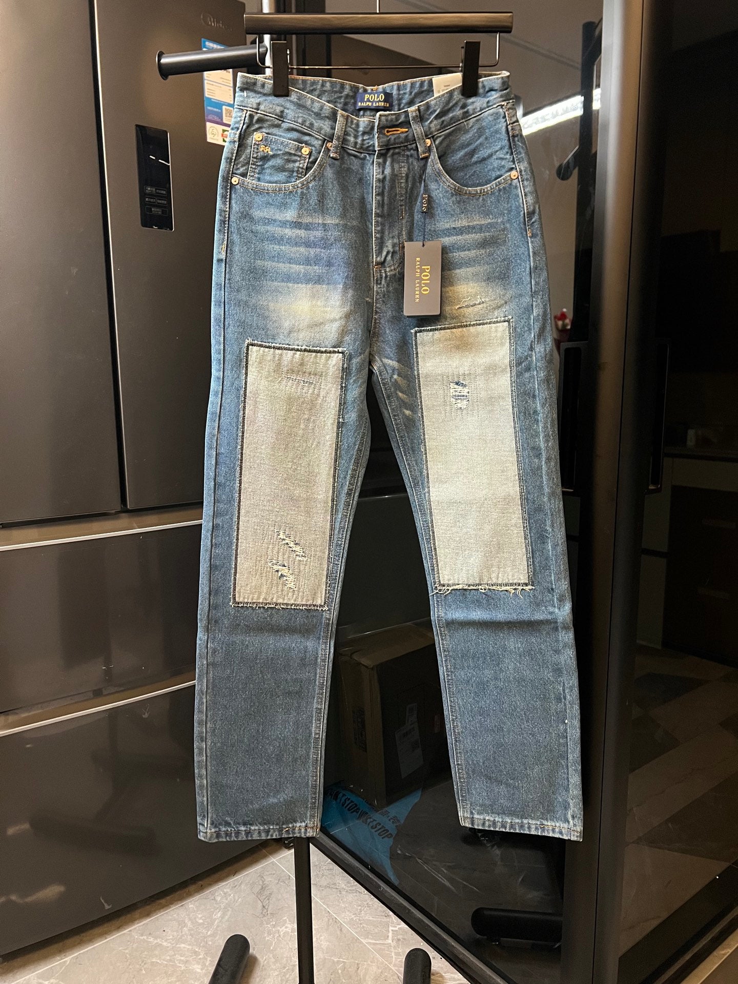Light-wash denim jeans with beige patch panels on front legs and straight fit