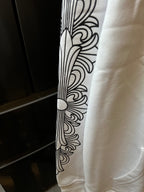 Light cream hoodie sleeve with black line-art floral pattern.