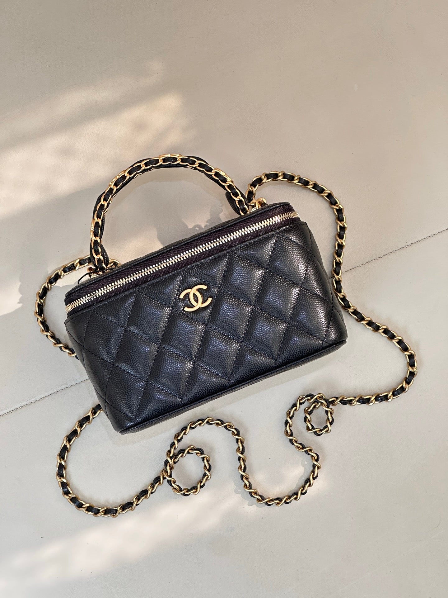 Chanel quilted mini bag in dark navy with gold zipper trim and chain strap