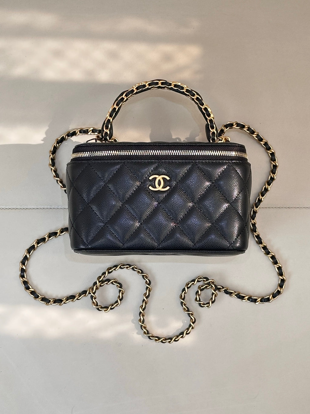 Chanel quilted mini bag in dark navy with gold chain handles and top zipper