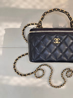 Chanel quilted mini bag, dark navy, close view of gold zipper and chain