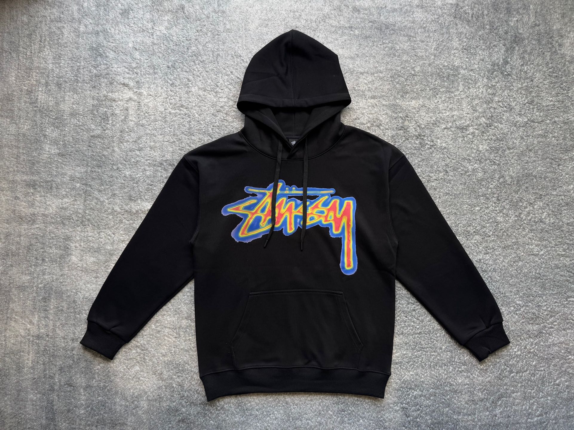 Black pullover hoodie with front Stussy graphic, hood and kangaroo pocket