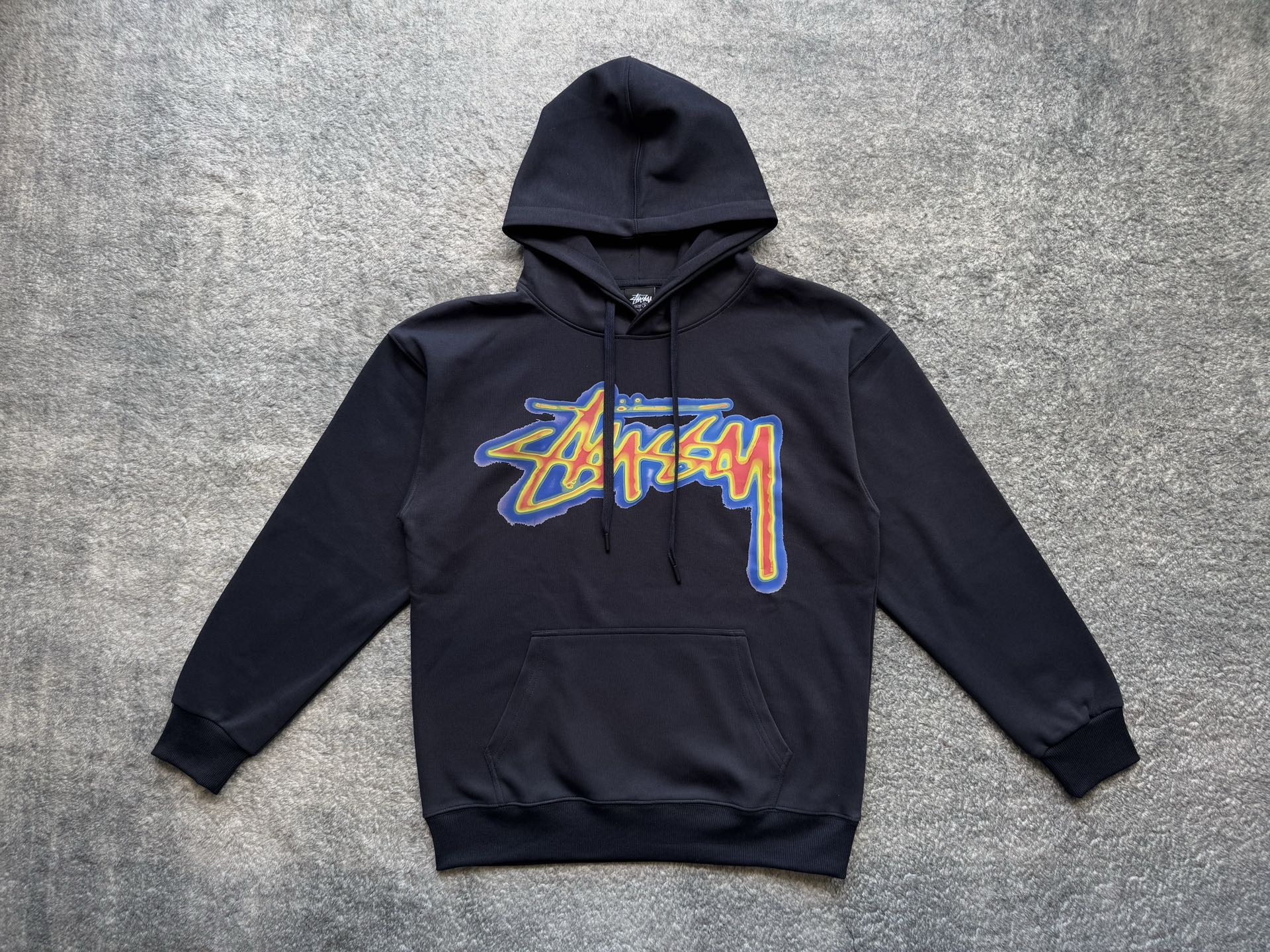 Dark pullover hoodie with front Stussy graphic, hood and kangaroo pocket