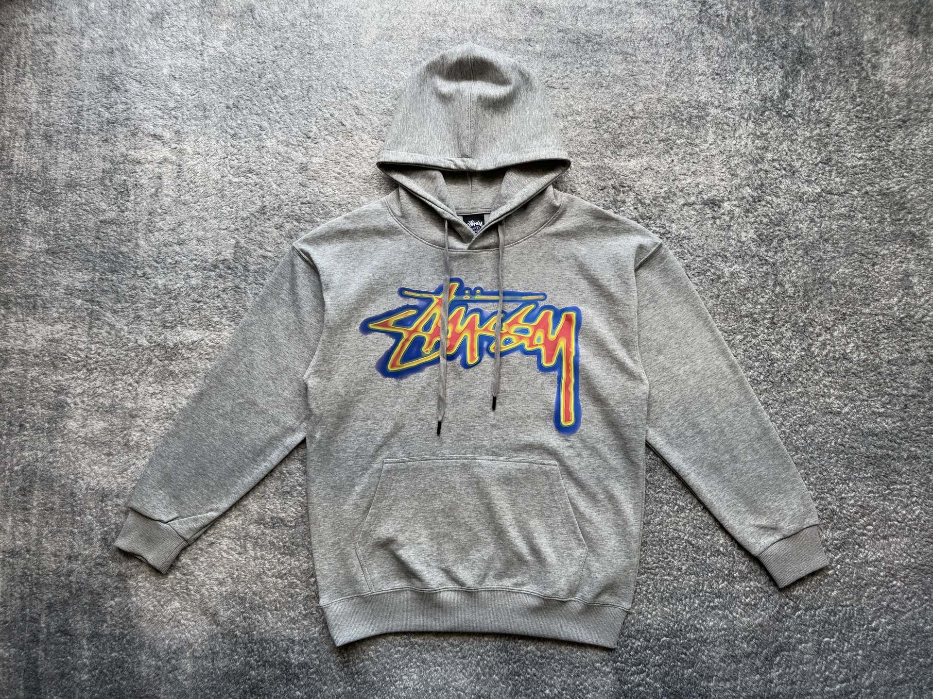 Gray pullover hoodie with front Stussy graphic, hood and kangaroo pocket