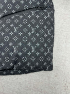 Louis Vuitton monogram puffer jacket hem with buttoned tab detail, dark gray.