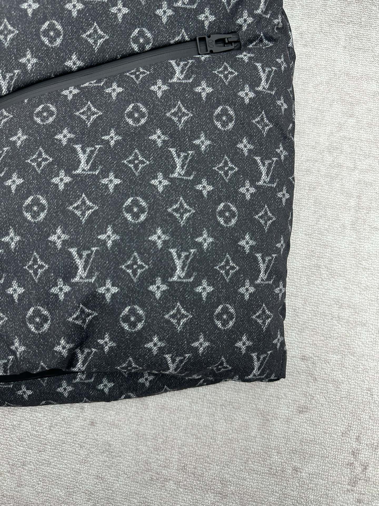 Louis Vuitton monogram puffer jacket hem with buttoned tab detail, dark gray.