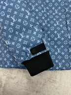 Blue Louis Vuitton monogram jacket with black strap detail near zip and pocket area