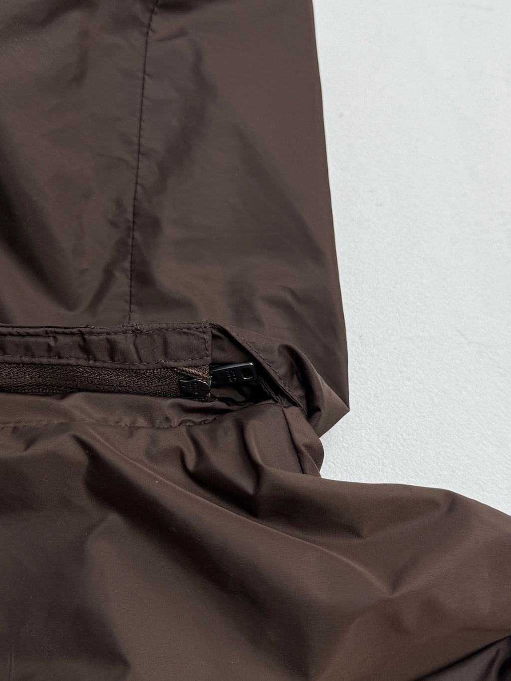 Brown jacket hem with elastic drawcord and zipper trim