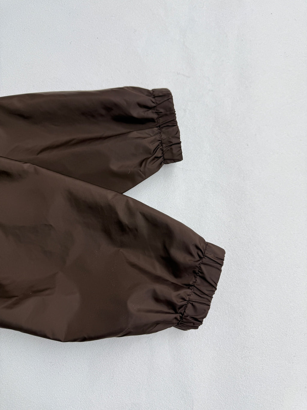 Long brown jacket sleeve with gathered cuff and elastic hem