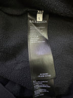 Inside neck label on dark hoodie with size and brand information