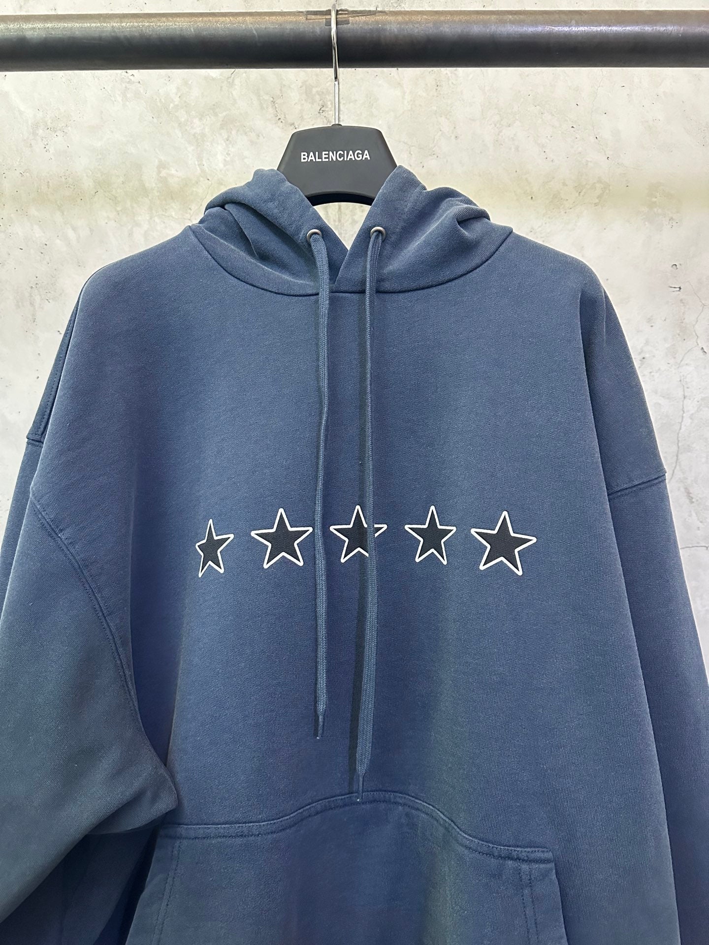 Balenciaga long hoodie close-up: blue with star and lightning logo on the chest