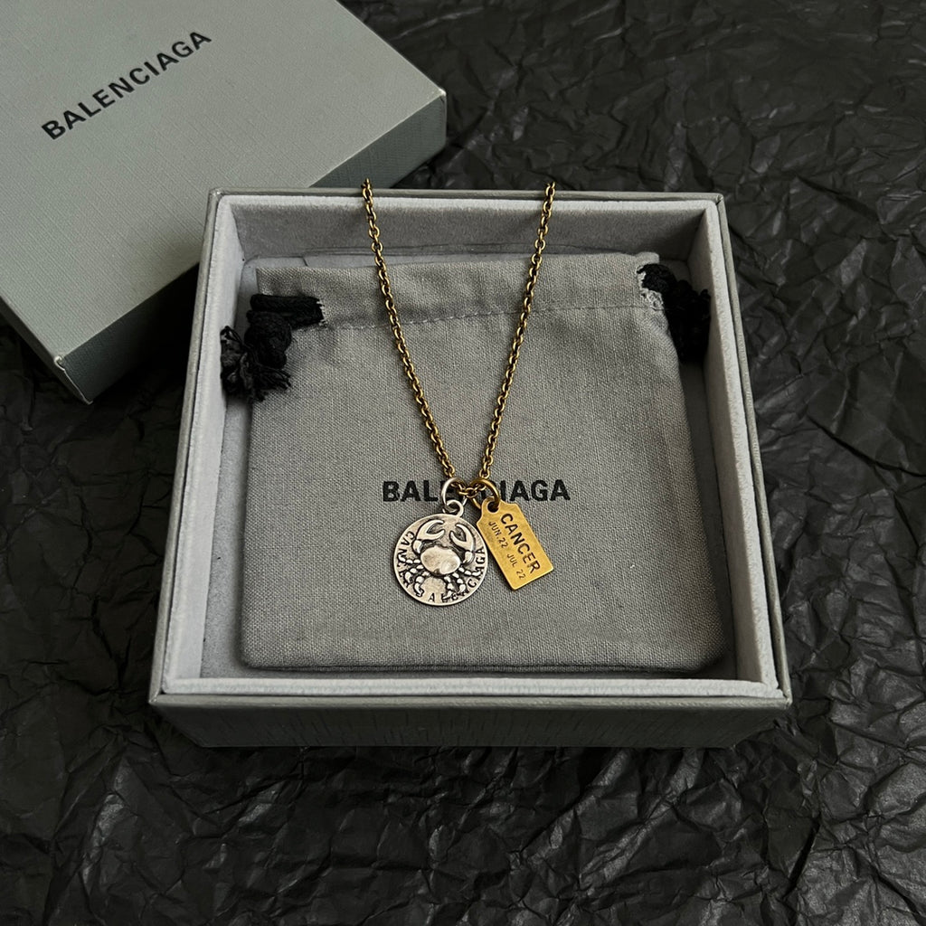 Gold chain necklace with circular silver charm and gold Cancer tag in gift box