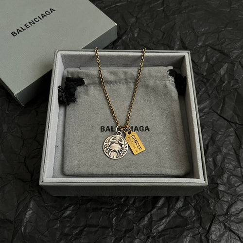 Gold chain necklace with circular silver charm and gold Cancer tag in gift box