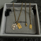 Gold chain necklace with circular silver charm and gold Cancer tags in gift box