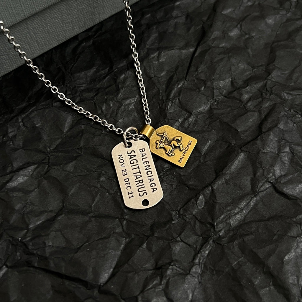 Silver-tone charm necklace with round, gold horse, and document-style pendants