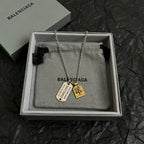 Balenciaga charm necklace with dog tag and small medallion pendants in silver tone