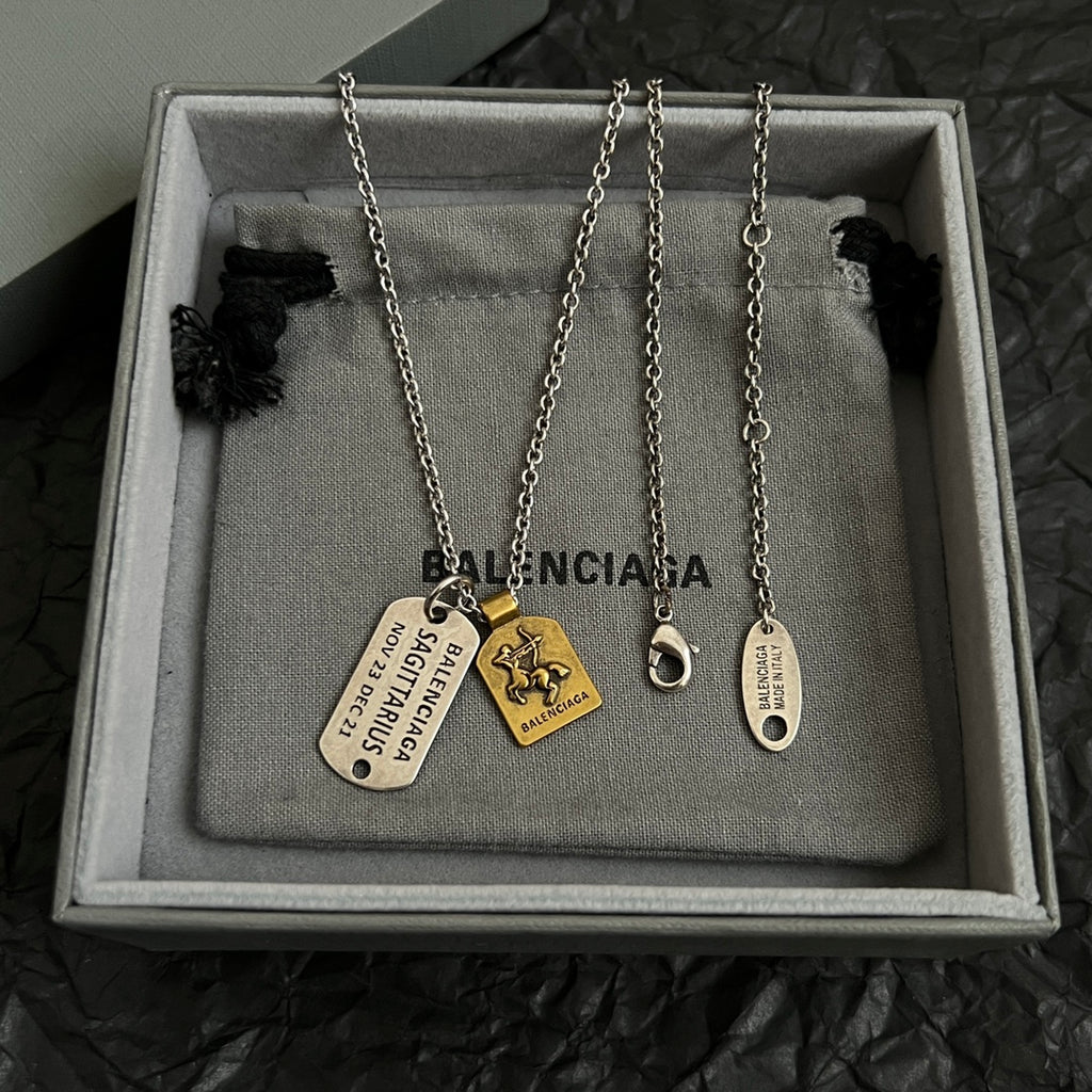 Balenciaga charm necklace with multiple dog-tag pendants on jewelry pouch in box