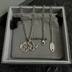 Balenciaga multi-charm necklace set with round logo pendants on silver chains