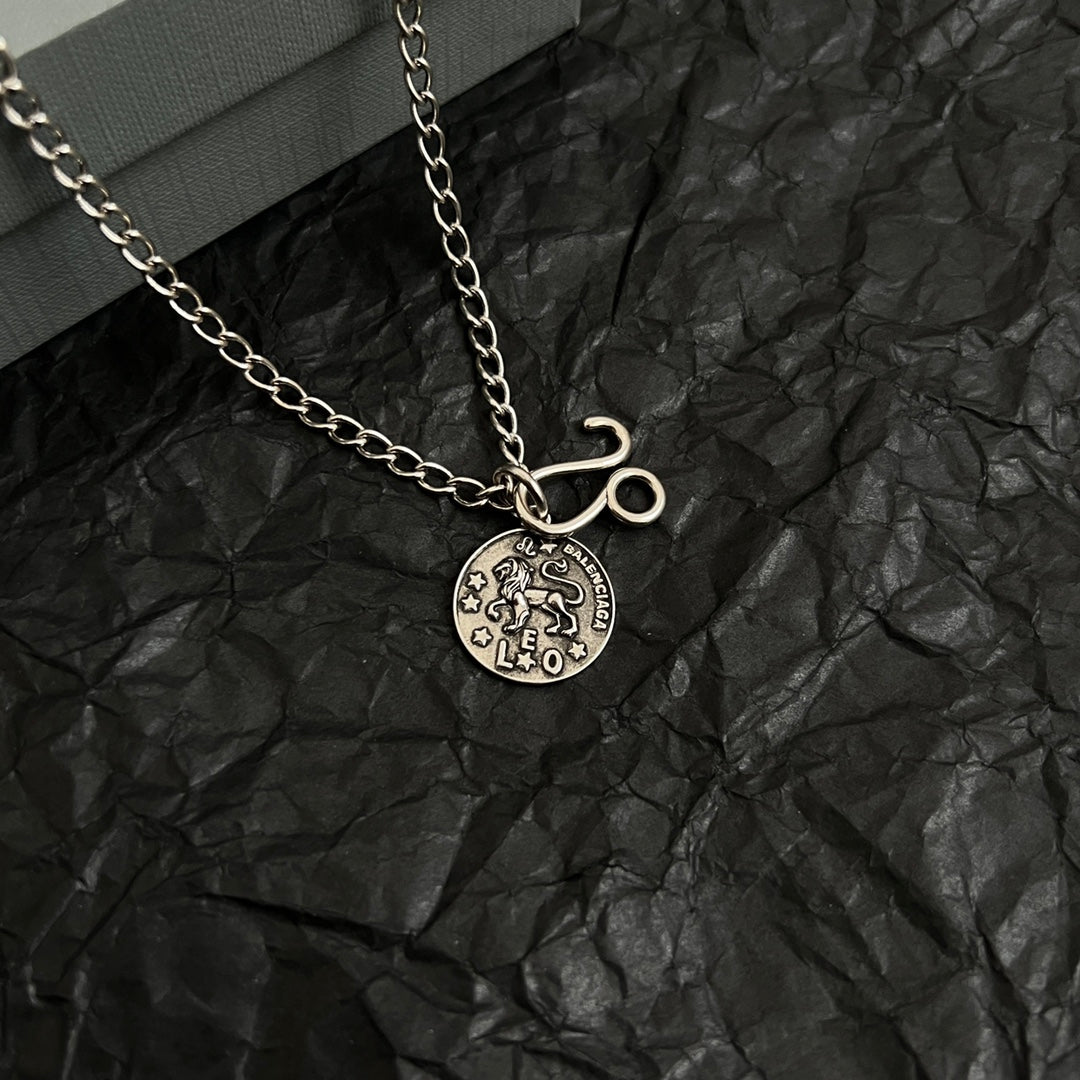 Balenciaga charm necklace with round logo pendant and hook charm on chain