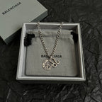 Balenciaga charm necklace with round logo pendant and hook charm on chain