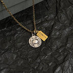 Gold chain necklace with circular silver medallion and gold Cancer charm tag