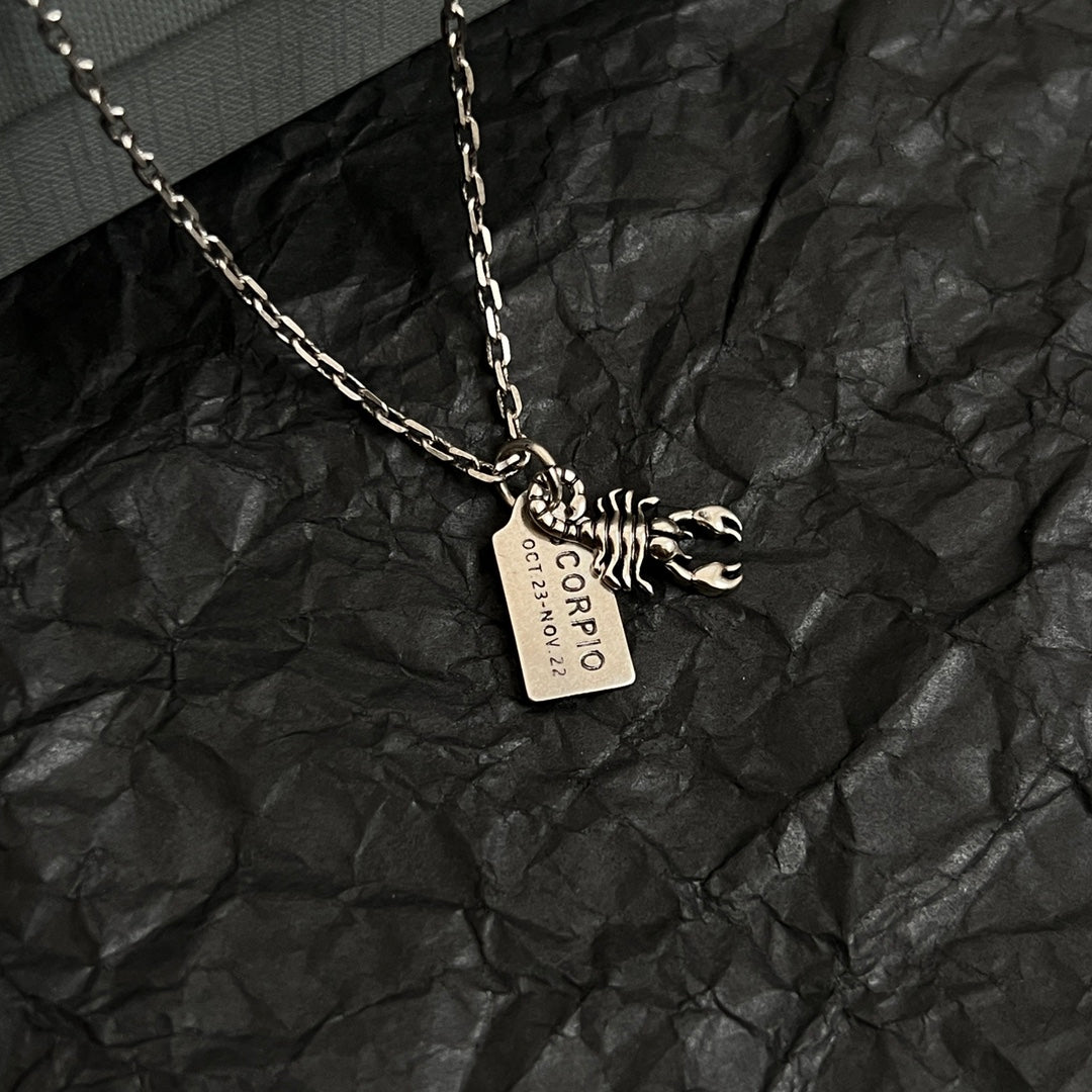 Silver necklace pendant with animal claw charm and engraved rectangular tag
