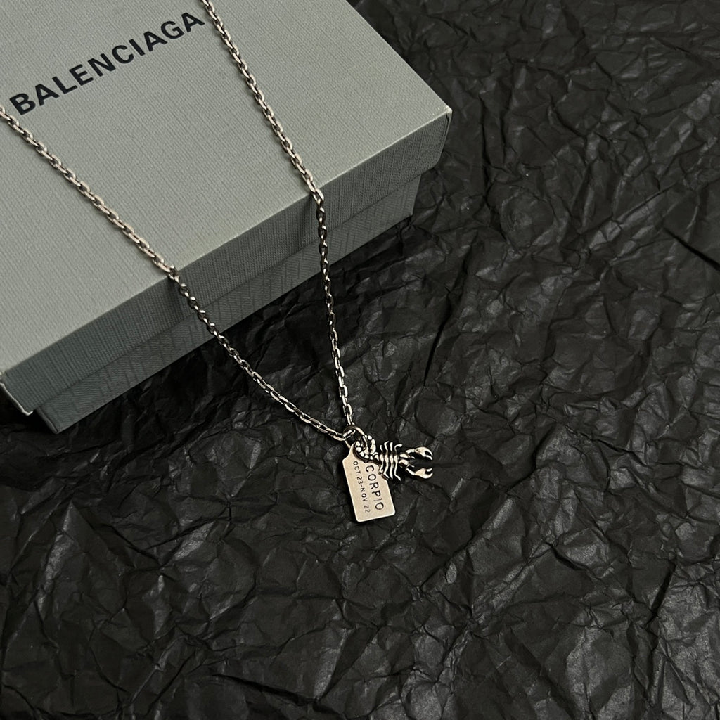 Silver chain necklace with rectangular tag and animal claw charm pendant