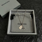 Balenciaga necklace accessory in box, silver chain with charm pendant and engraved tag